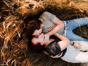 Is this a hidden sanctuary or a masterclass in romance? The overhead perspective nests them perfectly within the golden stalks, while the dappled light adds a layer of dreamlike, whispered intimacy.