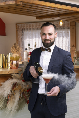 No bar em Béziers, o barman posa com uma bebida na mão, acrescentando um toque de frescor com a neblina.