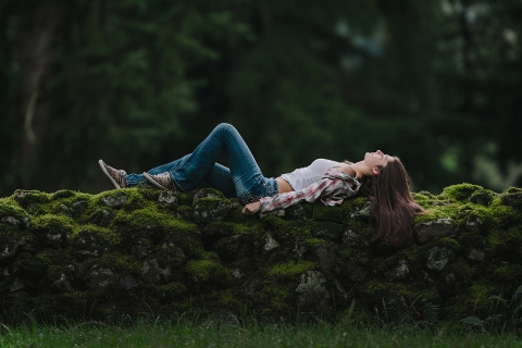 Garota de Seattle deitada em uma parede de pedra para um retrato de adolescente em Washington