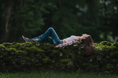 Seattle girl laying down on rock wall for a teen portrait in Washington