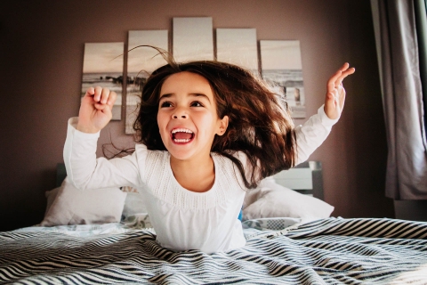 France Creative Lifestyle Portrait image of The little girl who jumps on the bed at home