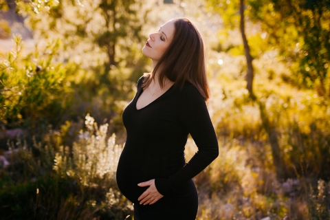 Herault Lifestyle Photographer created this artistic portrait of a pregnant woman in a black dress at sunrise