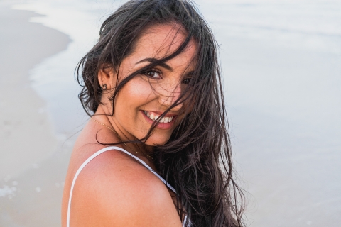 Maceio Lifestyle Photographer created this artistic portrait of a young woman with wind-blown hair at the shoreline