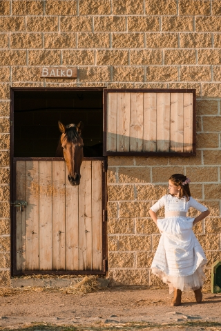 Esta é uma foto de estilo de vida de Madrid, de uma garota em um vestido branco com um cavalo