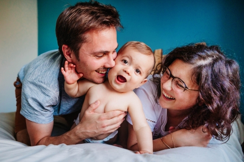 Esta é uma imagem de estilo de vida. Retrato de família na França na casa do casal na cama