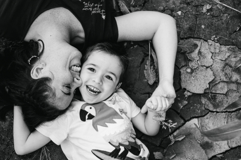 This is a lifestyle image from Doubs of mom and child who and end up lying in the mud