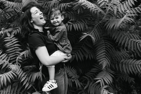 Esta é uma foto de estilo de vida de Doubs, de uma criança nas samambaias com a mãe em BW