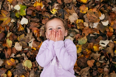 Lifestyle Photographer Dijon portrait child laying in autumn leaves