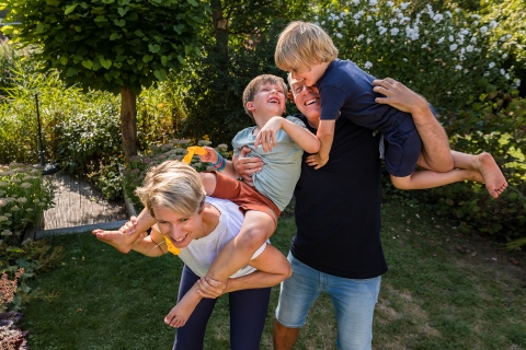 Mãe e pai seguram seus dois filhos pequenos para um retrato nas árvores de Weesp Amsterdam