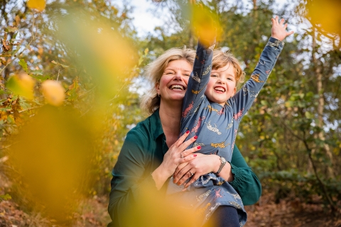 An Amsterdam mother hold her daughter near the trees displaying their fall colors