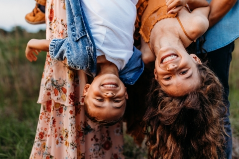 In Huntsville, Alabama, a lifestyle portrait captures the pure joy as a brother and sister hang upside down, laughter and giggles echoing through the air