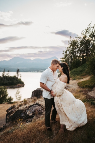 Eagerly anticipating their little one, new parents to be strike a pose on the picturesque bluffs near the water in Cascade Locks, Oregon for a lifestyle portrait