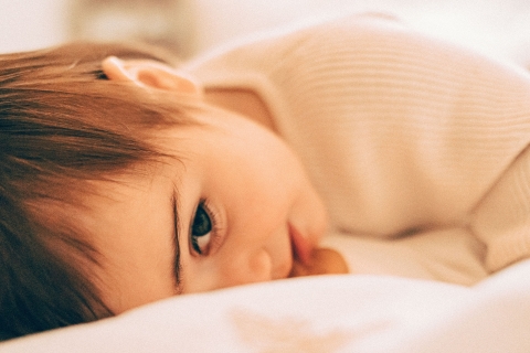 Este retrato de estilo de vida captura um bebê tímido em Seattle, Washington, espiando sorrateiramente um convidado misterioso. Um rosto adorável cheio de admiração.