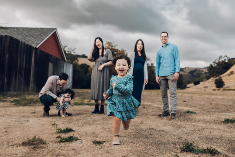 A lifestyle image created at Hayward, CA captures the in-law family's bond, with the oldest cousin breaking free from the group, laughing and racing towards the camera.