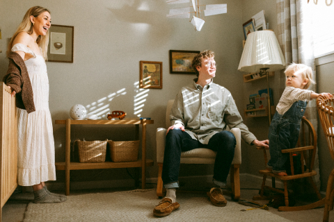 A foto mostra uma mãe, um pai e um menino juntos em um quarto aconchegante em sua casa em Vancouver, WA, parecendo confortáveis ​​e felizes no que parece ser o quarto do menino.