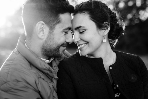 Na França, um fotógrafo tirou uma foto em close de um casal em preto e branco, sorrindo enquanto tocava o nariz durante a sessão de fotos.