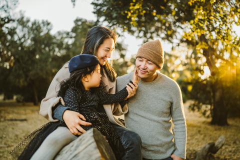 In Palo Alto, California, near sunset, a lifestyle photographer captured a sweet image: a cute girl touching her dad's beard in the park while her mom watched and smiled.