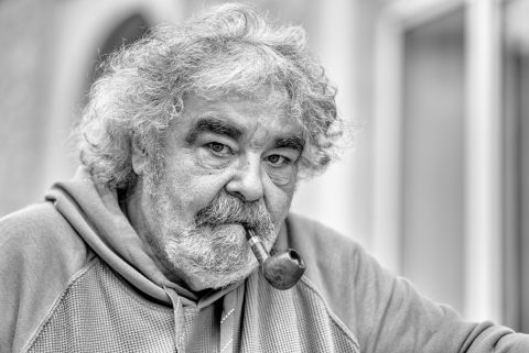 Pescador francês posa para retrato enquanto olha para a câmera com seus cabelos grisalhos, barba e cachimbo em Toulon, Var, PACA, França.