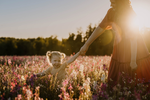 Em Silverton, Oregon, uma menina puxa animadamente sua mãe por um vibrante campo de flores, enquanto suas risadas ecoam enquanto elas apreciam a beleza e as cores do prado florido.