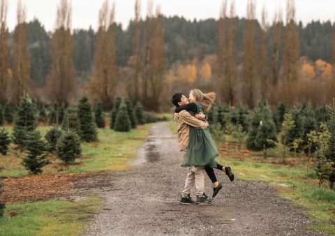 Em Woodinville, Washington, um casal alegre está cercado por exuberantes árvores perenes do noroeste do Pacífico, suas risadas e felicidade são evidentes enquanto eles se deleitam com a beleza natural do cenário florestal.