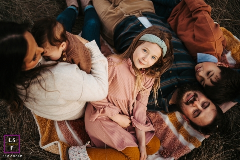 In North Boneville, Washington, a heartwarming lifestyle portrait captures a family huddled together on a blanket, while an overhead angle adds a touch of depth to the scene