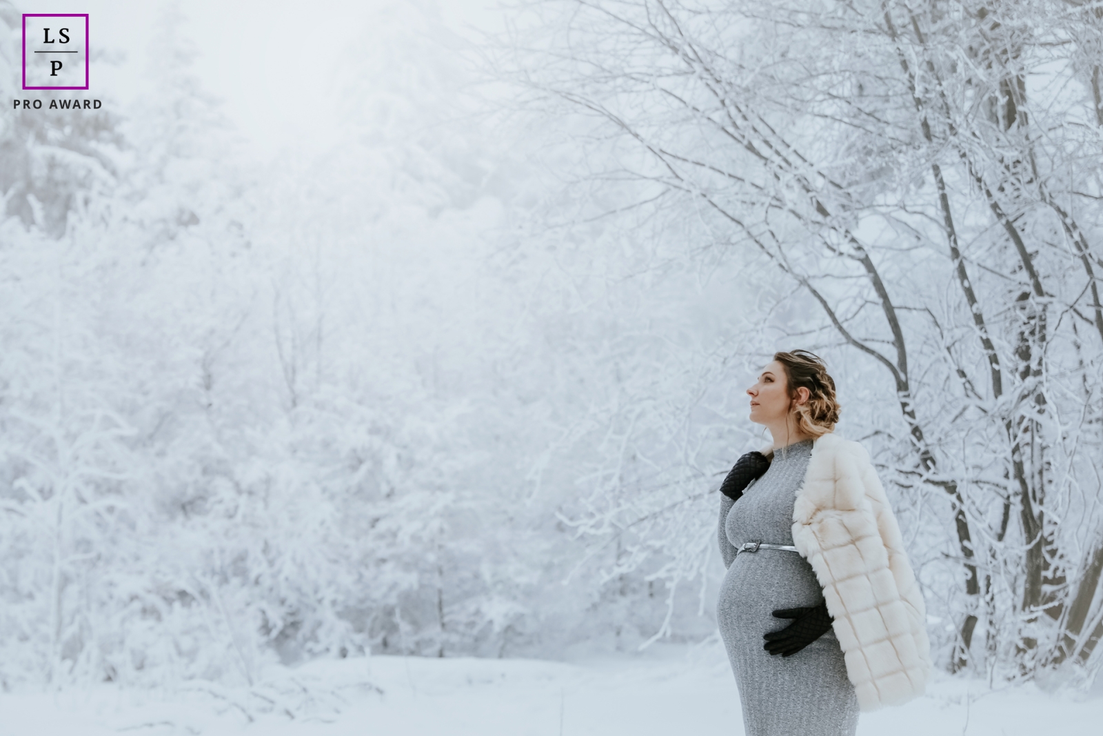 Amidst the icy winter chill of Alsace, France, a brave woman is embracing the snow during her beautiful Polar pregnancy session