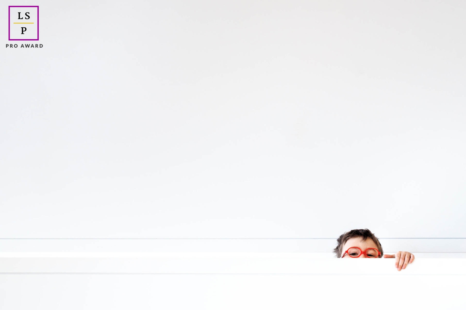 This young boy in Lyon, France, stands out against a white background, creating a minimalist yet memorable portrait