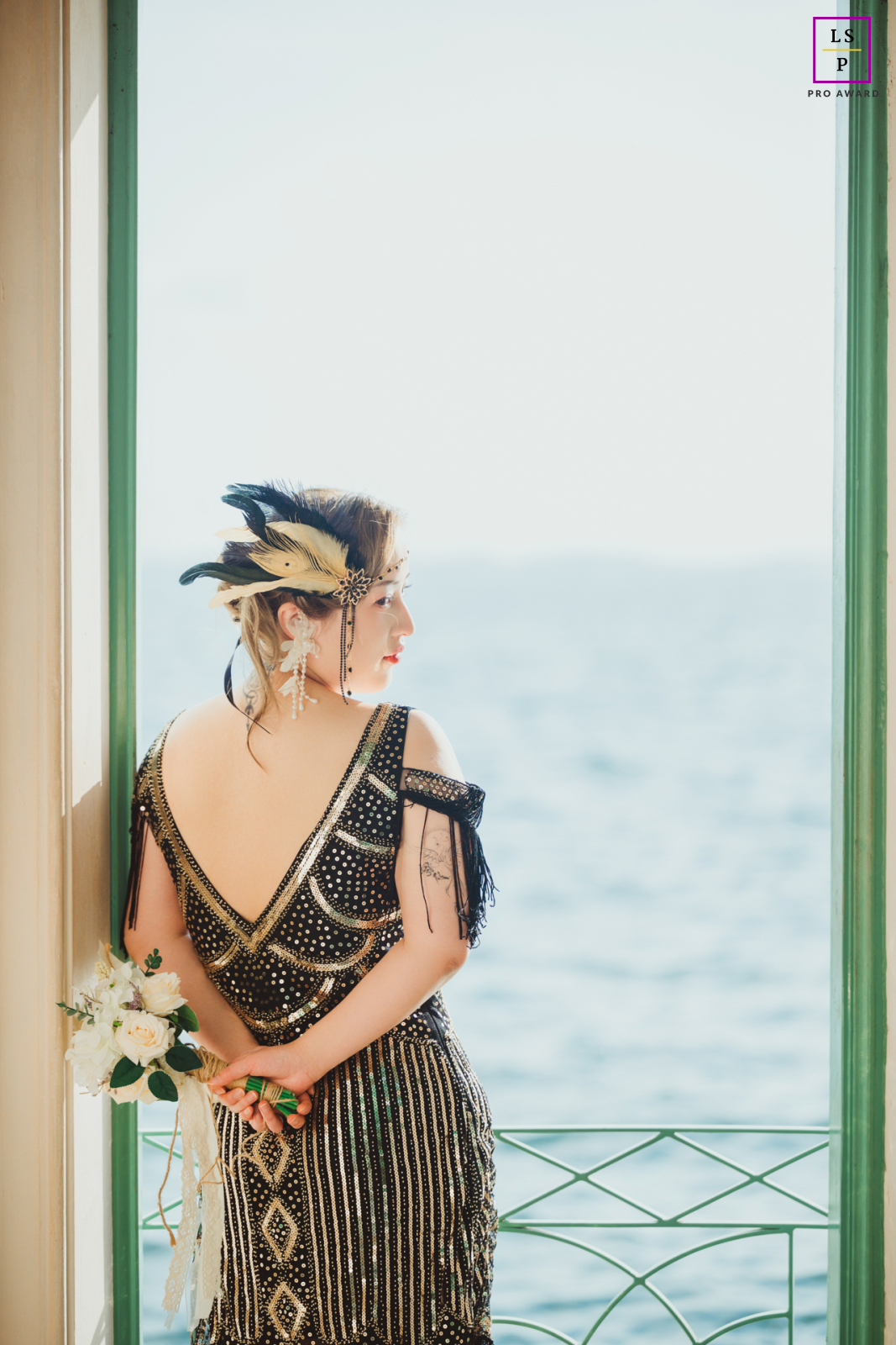 Uma jovem mulher usando uma roupa estilo flapper vintage é capturada em um retrato de estilo de vida em Miami, Flórida. Contra um lindo pôr do sol no mar, ela olha para trás, adicionando à vibração despreocupada e nostálgica da imagem.