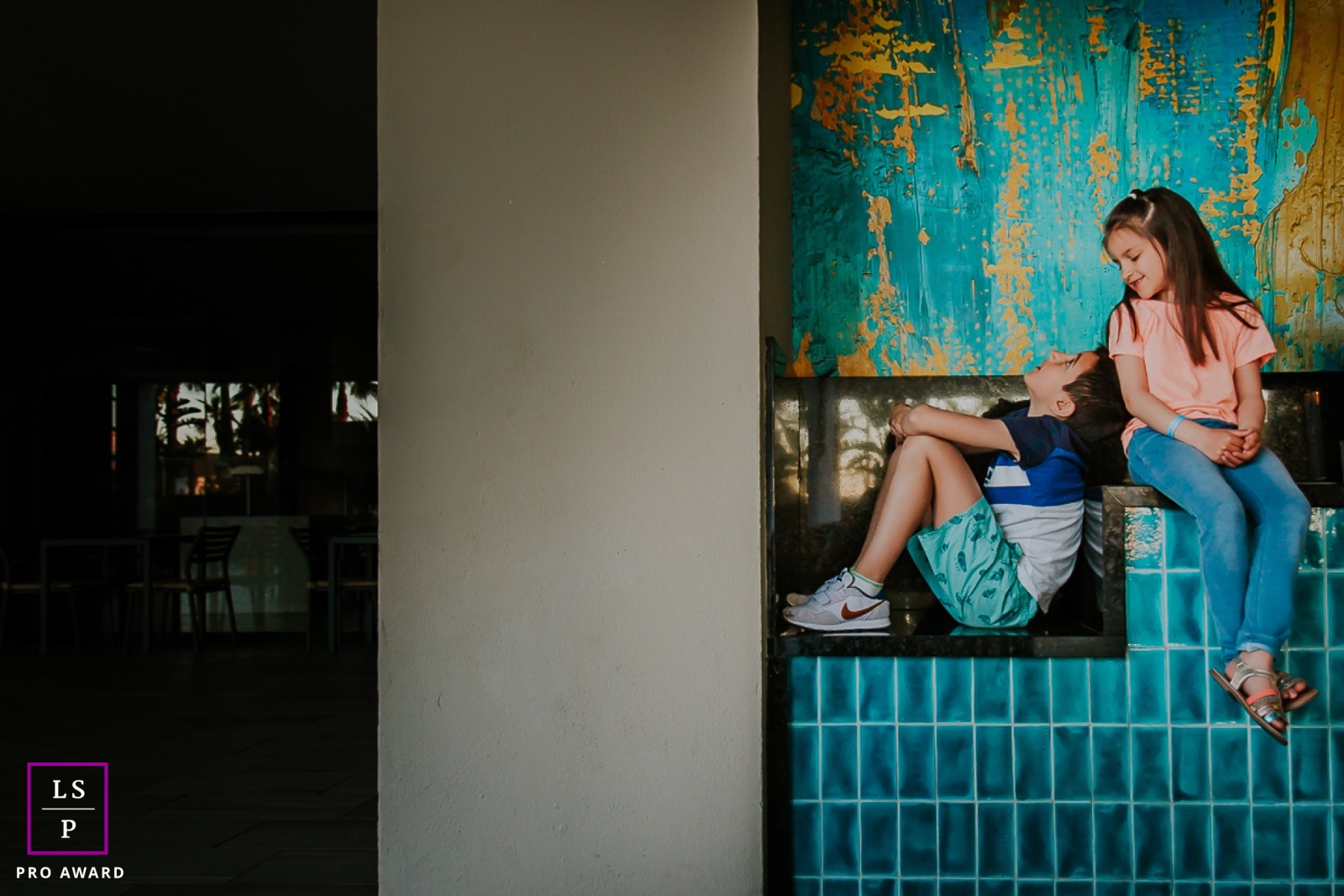 Brother and sister capture a stylish lifestyle portrait while perched on a picturesque wall in the beautiful city of Paris