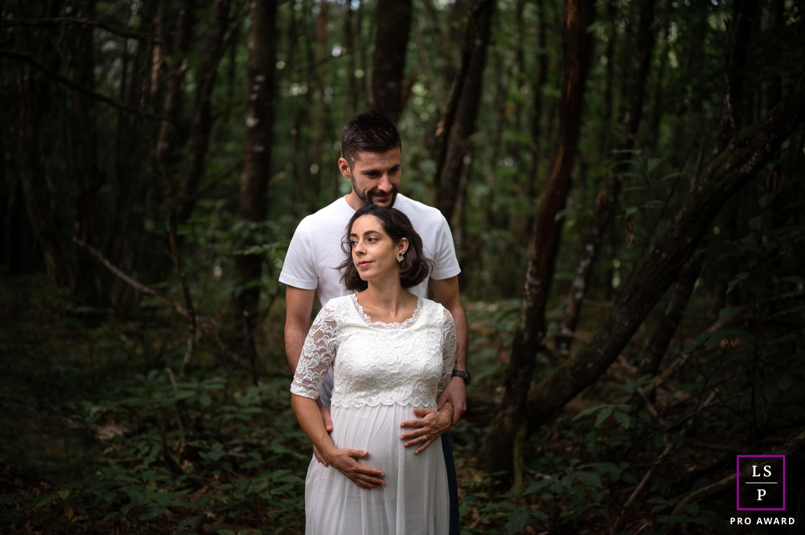 O amor entre este casal é palpável enquanto eles se abraçam na floresta, com a futura mamãe embalando carinhosamente sua crescente barriga