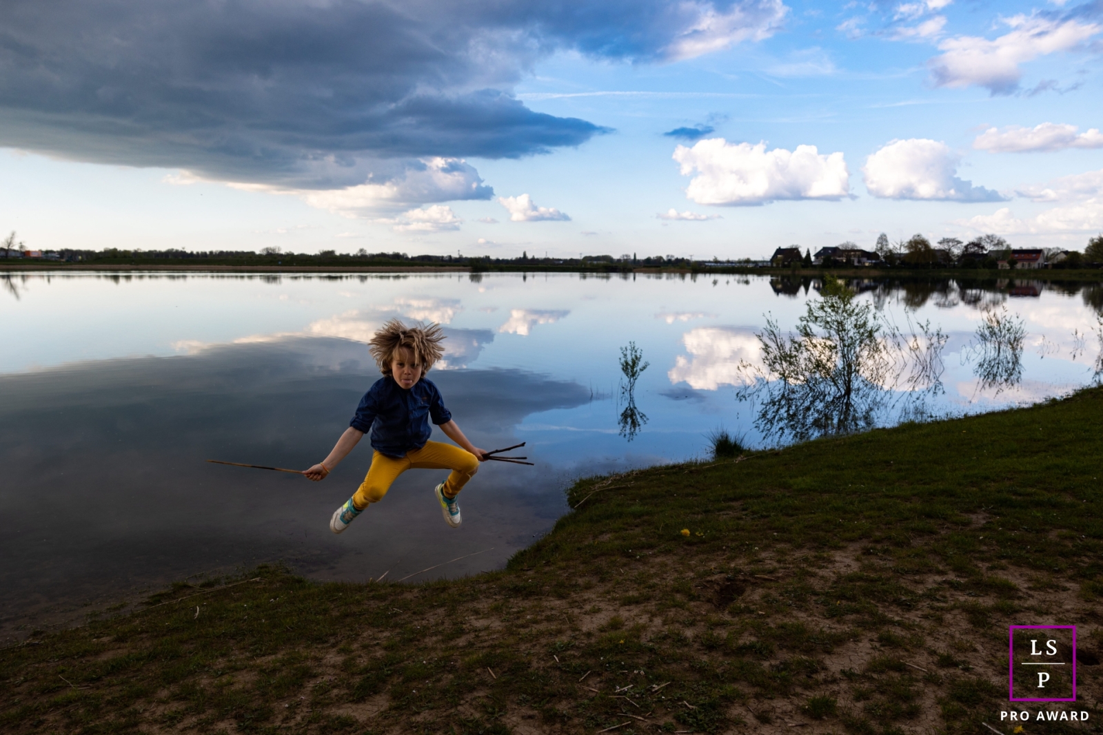In Nijmegen, Netherlands, a young boy is captured in mid-air as he leaps with the glistening water behind him