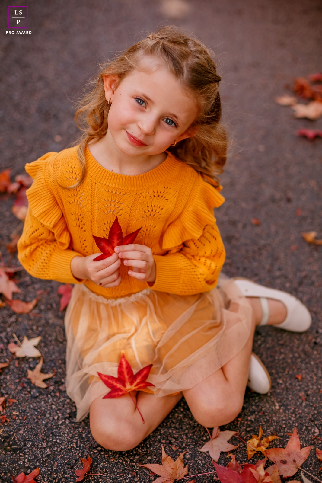 A portrait of a sweet girl lovingly holding a leaf from a plane tree in Curitiba