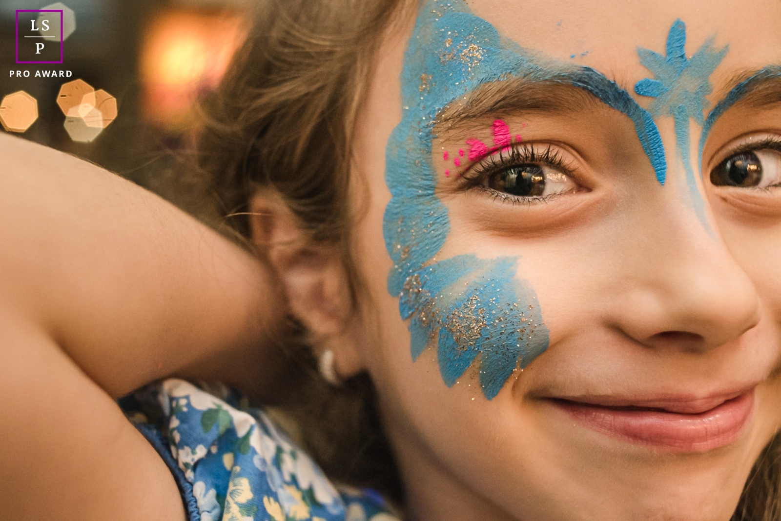 A girl in Campo Grande, Mato Grosso do Sul, smiles at the camera with artistic face paint, showcasing a vibrant and expressive lifestyle portrait