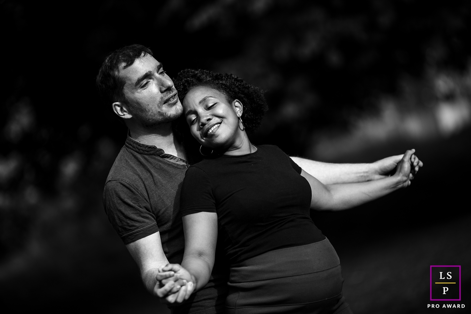 Um casal feliz em preto e branco dançando ao som do canto dos pássaros, mergulhando na serenidade das árvores em Lyon