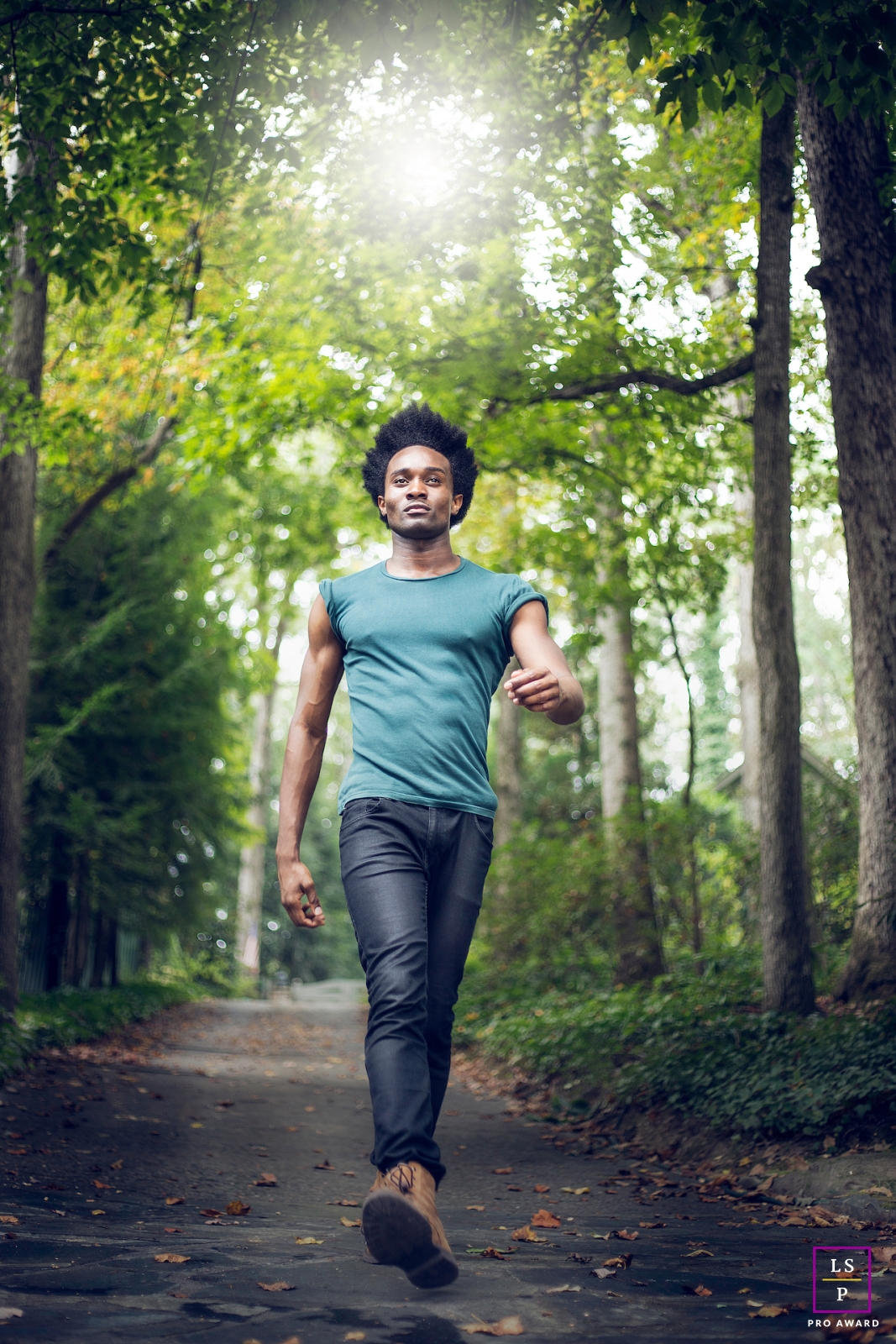 A man in Atlanta, GA takes his daily walk on a paved trail surrounded by trees in a peaceful forest setting