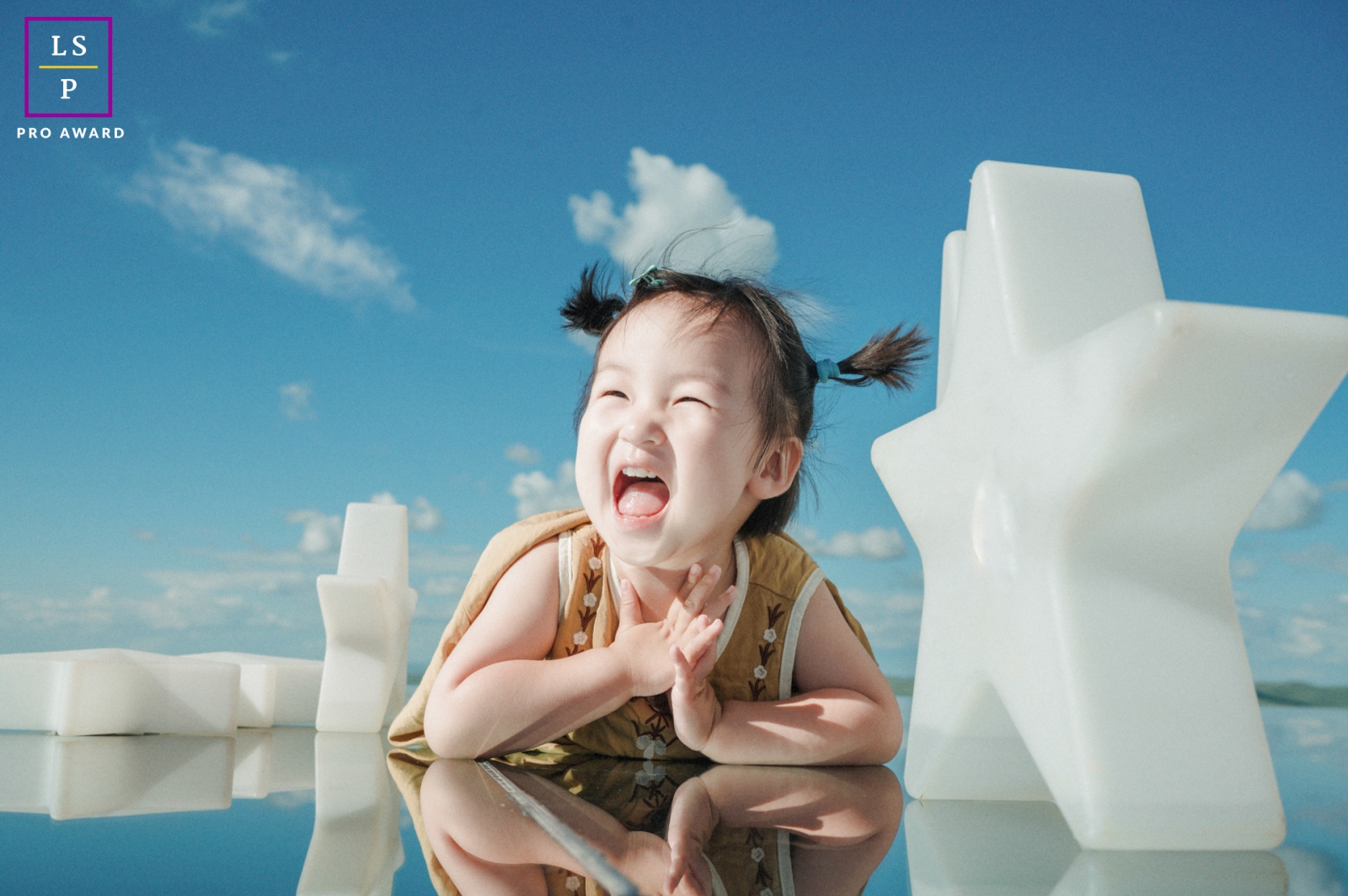 A young girl in Inner Mongolia is captured in a portrait, showcasing her distinctive pigtails hairstyle. The image is further enhanced by a glass table, adorned with white stars, reflecting her love for them.