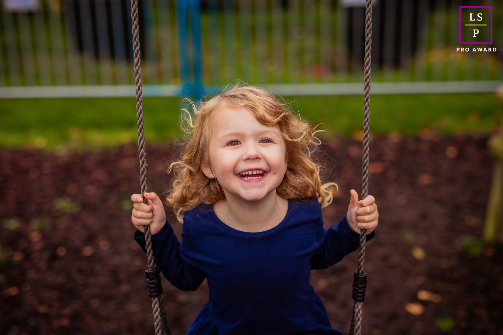 Em Overijssel, Holanda, uma menina balança alegremente, com o cabelo voando ao vento, enquanto ela ri de alegria