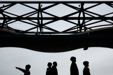 This Paris family appears in silhouette beneath a striking geometric canopy, each figure separated by posture and gesture. The child pointing adds curiosity and direction, while the minimalist composition transforms an ordinary walk into something graphic
