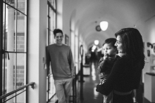 A family shares a candid portrait together beneath an arched hallway while sheltering from a rainy day in Seattle, Washington.