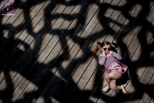 Retrato de uma menina atrevida em Paris, aproveitando o sol enquanto as sombras adicionam um toque gráfico ao cenário de estilo de vida.