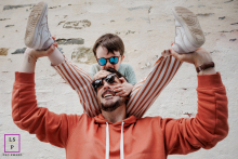 Paris Pai e filho sorriem enquanto o menino se senta nos ombros do pai.