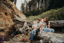 Na Costa do Oregon, EUA, pais aproveitam um dia de praia com seus filhos gêmeos sentados em um tronco.