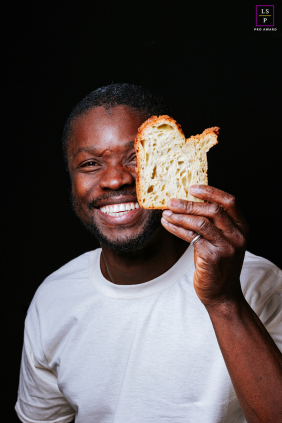 Baker Lifts Slice Of Bread Smiling With Craftsmanship And Joy In Playful Cauneille, France Portrait In Cauneille, the baker lifts a slice of bread like a prized sculpture, proudly revealing its airy texture beside an unforgettable grin. The portrait feels playful and honest, celebrating craftsmanship, personality, and the simple joy inside the loaf.