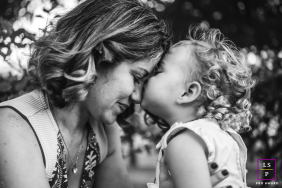A mother and daughter share a warm embrace in Maceió-AL. They are smiling.