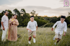 Parents hold their daughter while they watch their sons race in a competition in Sydney, New South Wales. The photo captures a family enjoying a day of sports together.