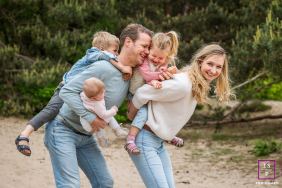 In Hilversum, The Netherlands, a family shares genuine smiles and embraces, their pure emotions and close connections evident. The candid photo beautifully captures their authenticity and the warmth of their relationship.