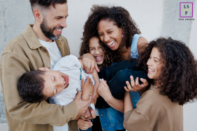 In Paris, France, a family enjoys time together, laughing and playing. They are captured in a joyful portrait, with everyone engaged and smiling.