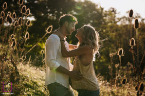 In Poleymieux-au-Monts-d'Or, Rhône, a couple shares a profile kiss at sunset, illuminated by sun rays in a session of complicity.