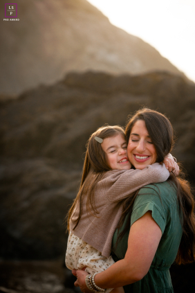 Portland Beach Embrace: Mother And Daughter Nuzzle In Soft Natural Light In Portland, Oregon, mom and daughter embrace on the beach, their faces nestled together, highlighted by soft natural light.
