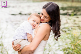Overijssel Mother and Child Cuddle Closely Outdoors, Faces Nestled in Nature In Overijssel, Netherlands, a mother and child cuddle closely outdoors, their faces nestled together and framed by natural surroundings.